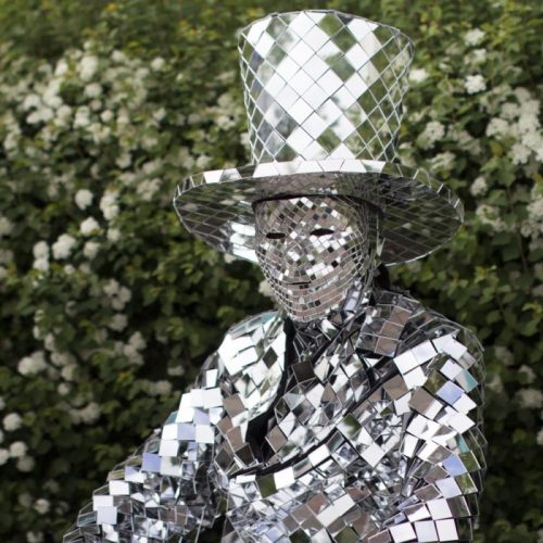 Sitting in the park area in Mirror man glass man performance costume