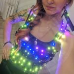 Model poseing in light up top corset that glow in blue/yellow colours