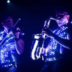 Musicians play on sax and vilolin in glowings outfit
