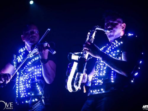 Musicians play on sax and vilolin in glowings outfit