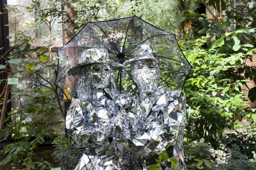 Couple in mirror costumes holding umbrella