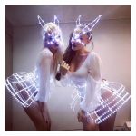 Girls making photos before performance in a LED light up cage mask of Bunny