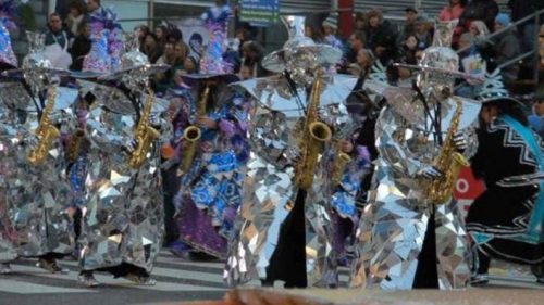 Mirror man "Wizard" costume on Mummers festival playng sax