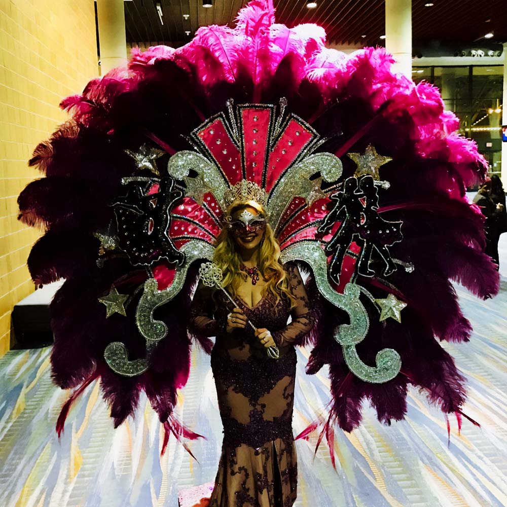 Giant feathers immediately make women's costume for Mardi Gras noticeable and memorable