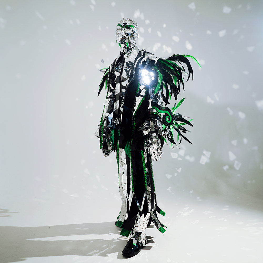 Mardi Gras men’s suit made of silver mirrored acrylic with green feathers, it looks both smart and a little scary.